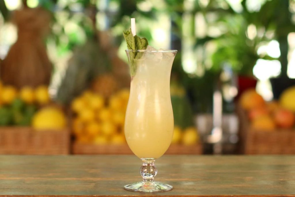 A Piña Colada, a classic tiki cocktail from Mixology Events virtual cocktail making classes, sits on a bar