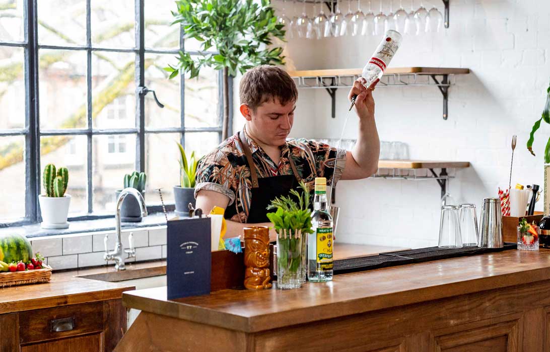 Male mixologist host at the front of a cocktail making class