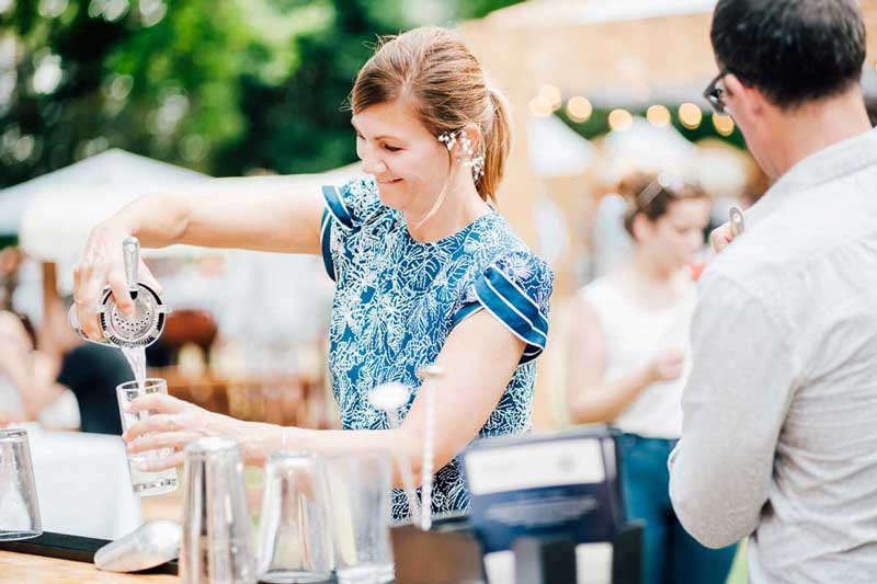 Woman pouring cocktail at an outdoor class