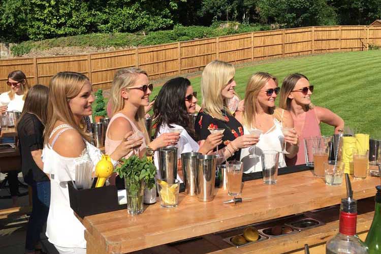 Women at a cocktail bar set up in a back garden