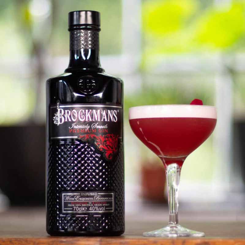 Bottle of Brockmans gin next to a clover club cocktail
