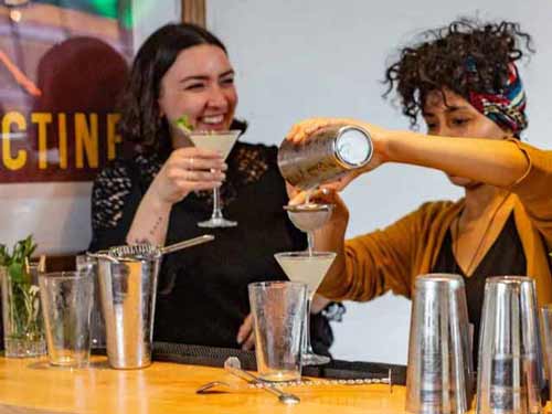 Two women enjoy a cocktail during a cocktail making class